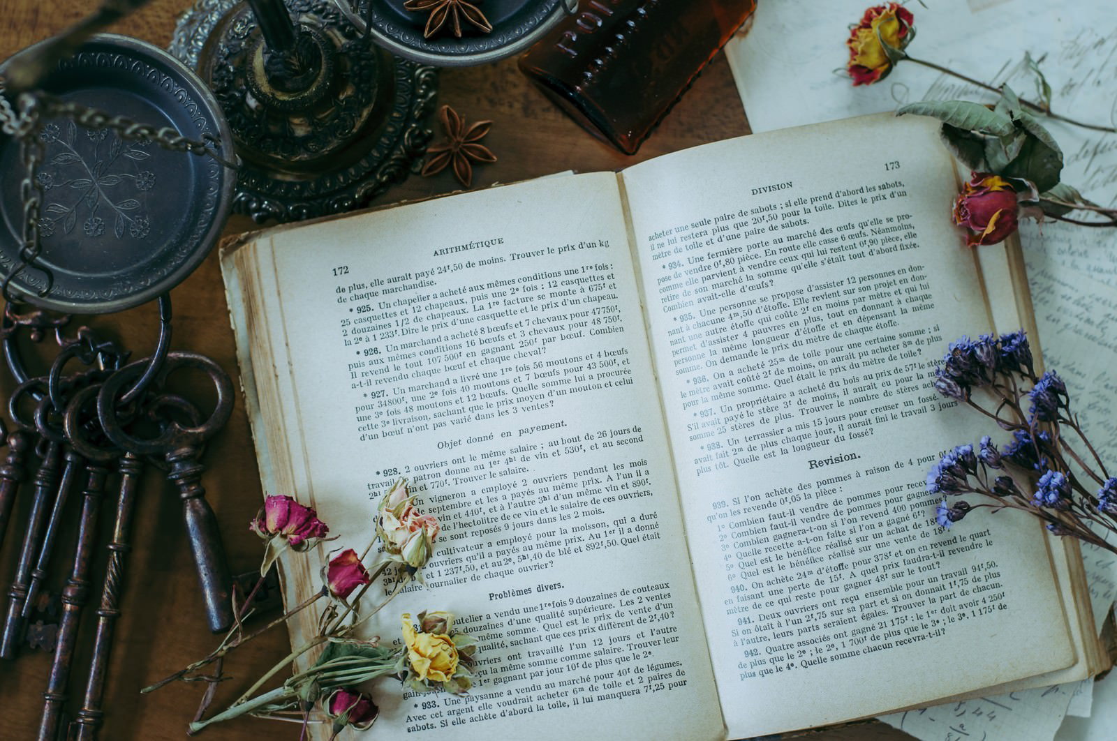 開かれた洋書の上に色とりどりのドライフラワーが散らばっている様子