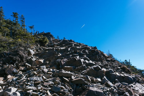 甲武信ヶ岳山頂直下の岩場と瓦礫帯、青空の登山風景