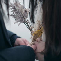 ドライフラワーの花束を握る女子高生の手元の写真