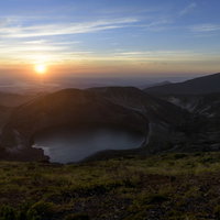 蔵王山の御釜とご来光、朝焼けに染まる火口湖の写真