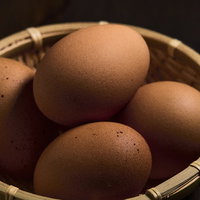 竹籠に盛られた卵 - 新鮮な生卵とゆで卵の食材の写真