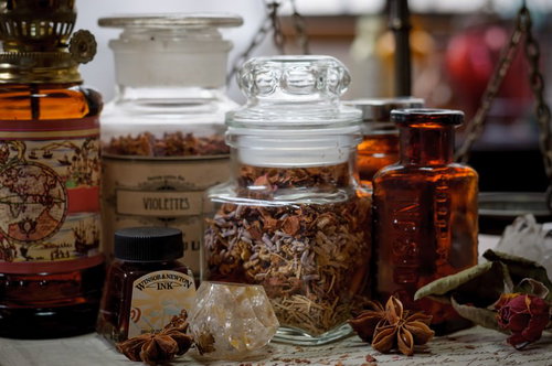 魔女の机に広がる古書と天然石とハーブ