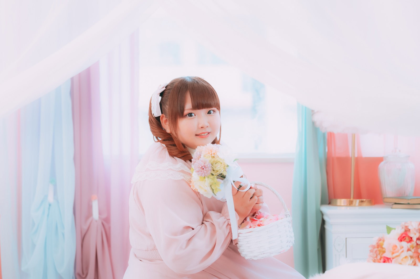 ピンク色のドレスを着てブーケを持つ笑顔の女性［モデル：あづき］