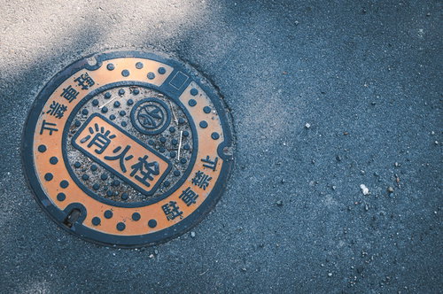 アスファルト道路に設置された消火栓のマンホール