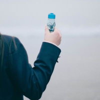 映画のような一瞬、ラムネの瓶を掲げた女子高生の後ろ姿の写真