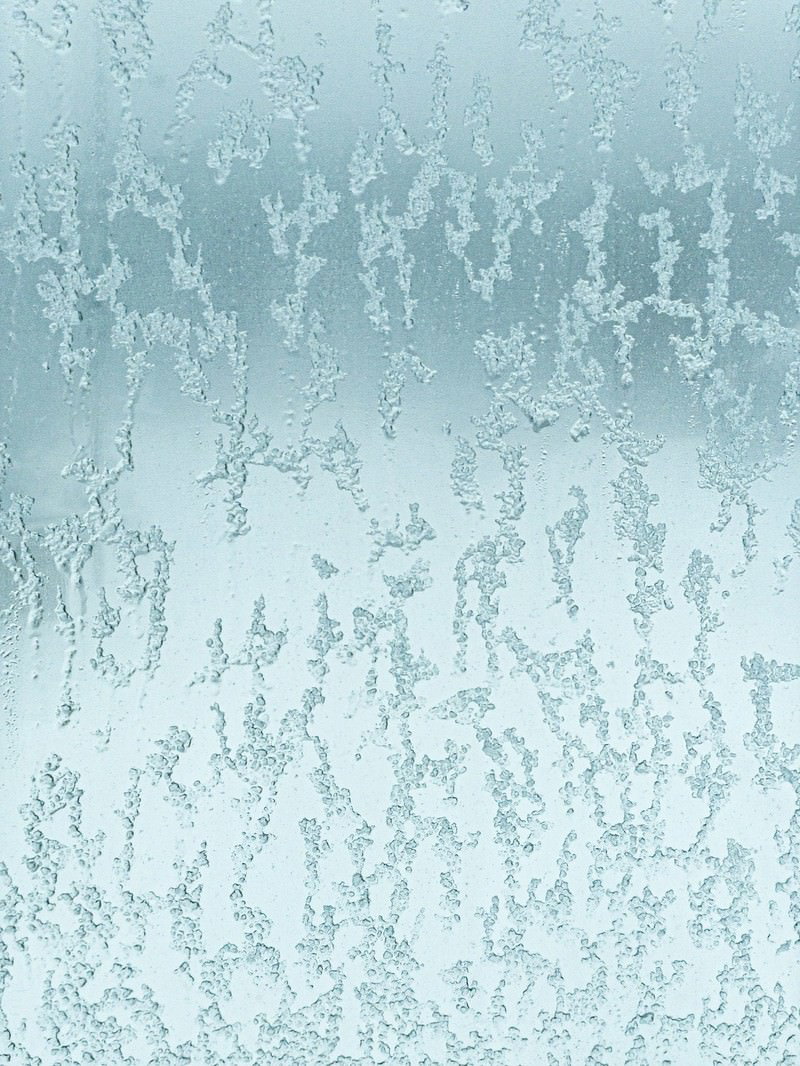 窓ガラスに張り付いた溶けた雪と結露による氷の結晶模様