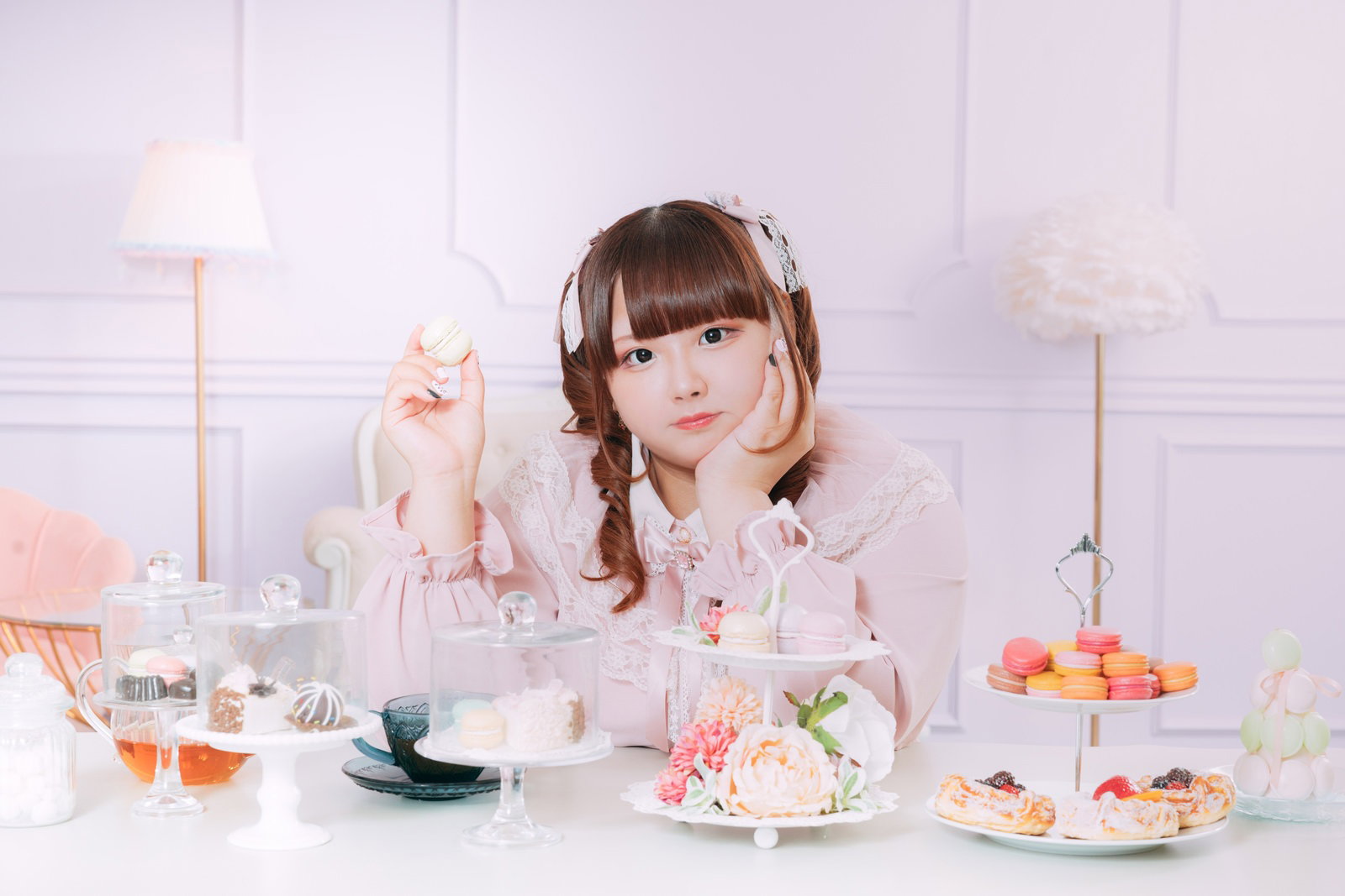 ピンク色のワンピースにツインテールの女性がスイーツとティーパーティーをしている［モデル：あづき］