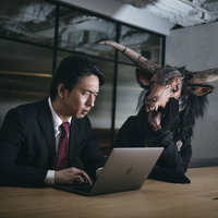 これ、残業代つかないからね。悪魔にささやかれるスーツ男性の写真