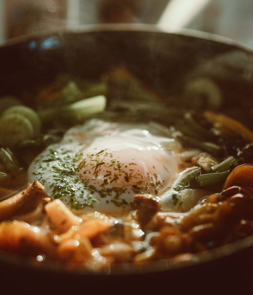 温泉卵がのった卵うどん、青ねぎと乾燥わかめのトッピング