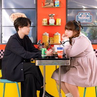 レトロなダイナーでぽっちゃり女子とデートする男性の写真