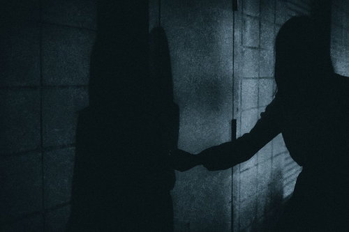 暗闇の扉をあける人影
