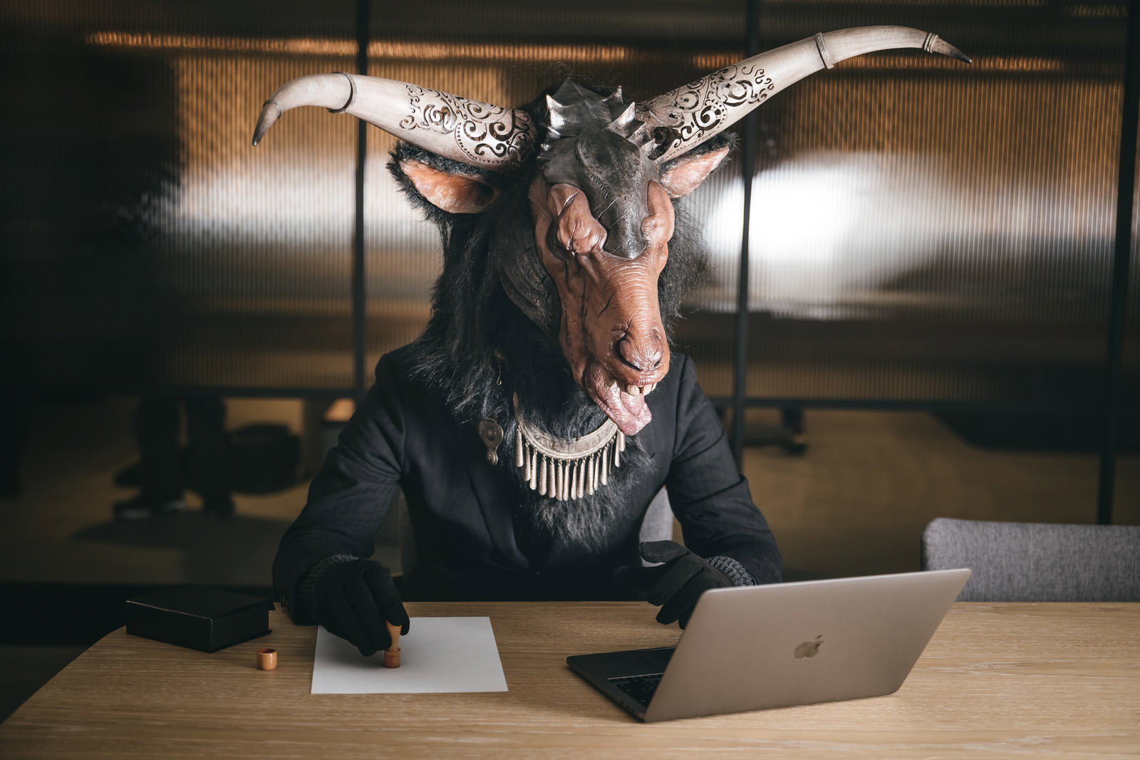 ヤギ頭の悪魔がオフィスで契約書にサイン