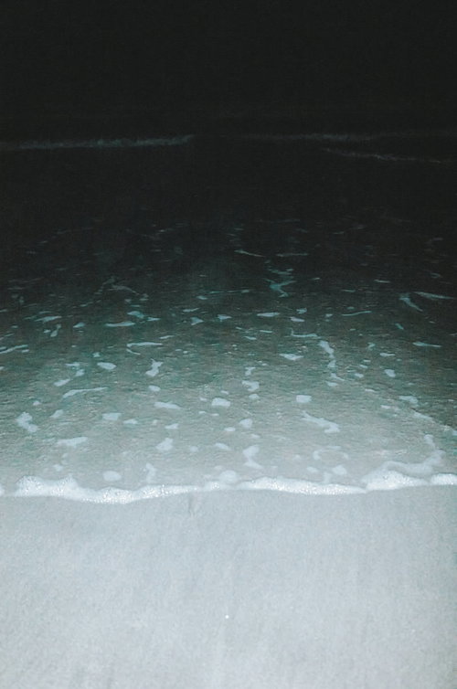 夜間の波打ち際に打ち寄せる波と砂浜の風景