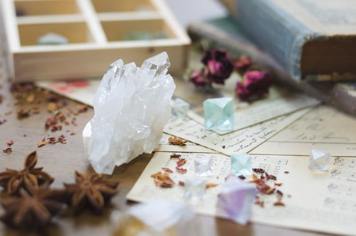 透明なクリスタルと魔法薬の材料が散らばる自然素材の配置