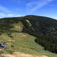 青空の下、緑の森林に覆われた西吾妻山への稜線の写真