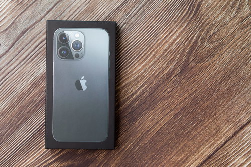 iPhone 13の箱を木目テーブルに置いた開封の儀