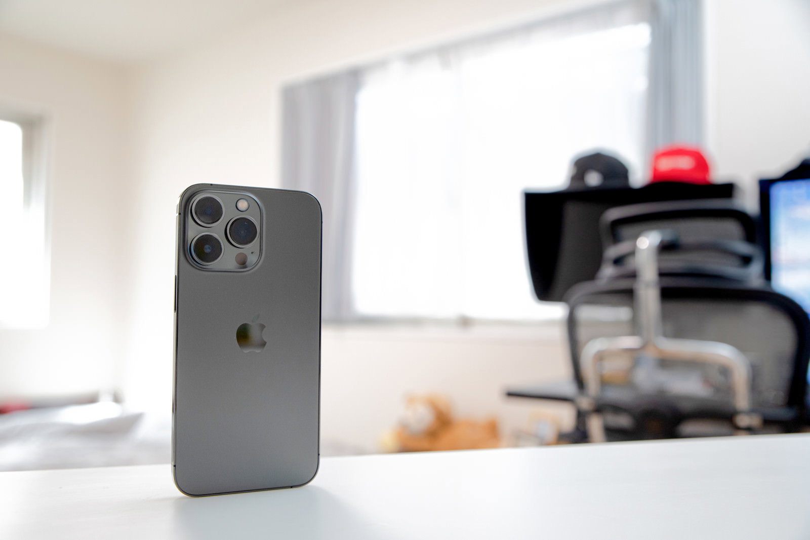白いテーブルの上に置かれたグレーのiPhone