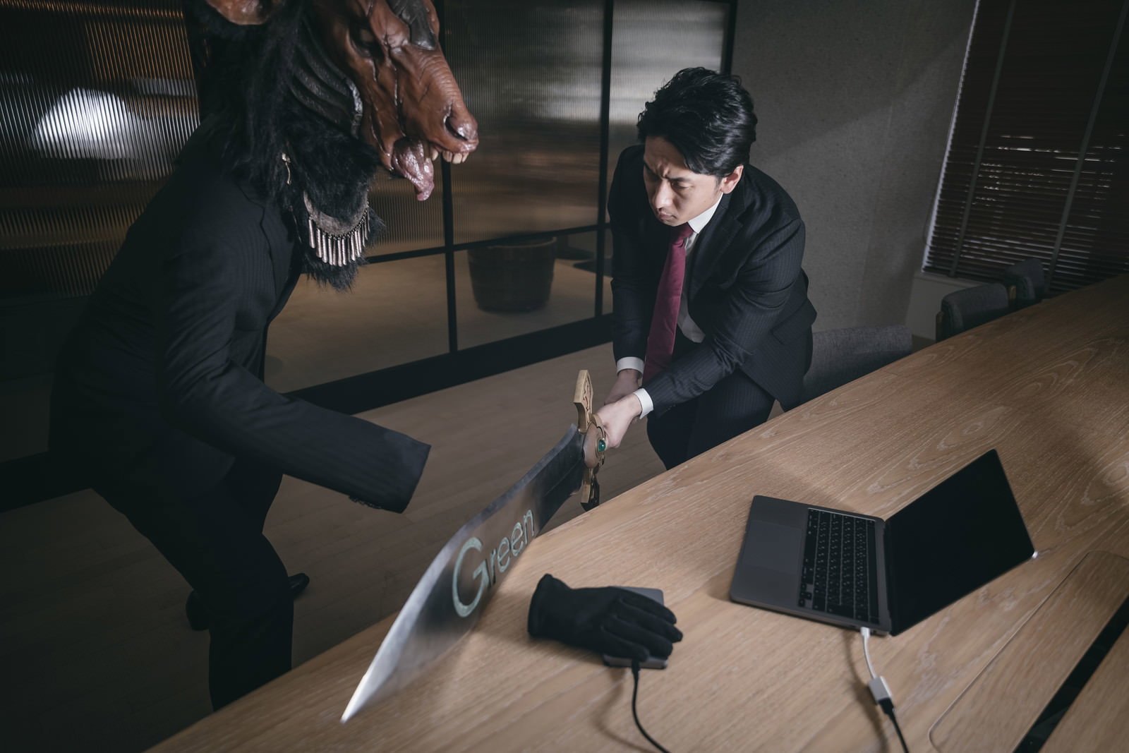 オフィスでスーツ姿の会社員が聖剣を手に魔神と戦っている［モデル：大川竜弥］
