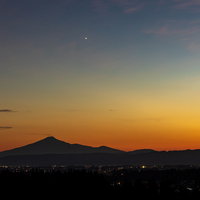 夕焼け空に浮かぶ鳥海山のシルエットと夜景グラデーションの写真