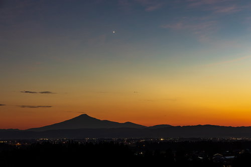 夕焼け空に浮かぶ鳥海山のシルエットと夜景グラデーション