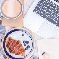 朝食のクロワッサンとノートパソコンでテレワーク開始の写真