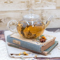 洋書の上に置かれたハーブティーとティーポットの写真