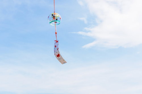 青空に吊るされた赤い夏の風鈴の涼しい風物詩