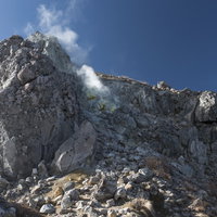 いたるところから沸き起こる噴気の焼岳の岩壁の写真