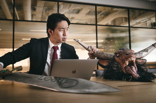 社内でモンスターをハントするスーツ姿の男性