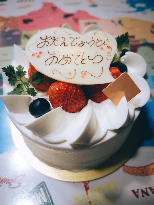 おたんじょうびおめでとうと書かれたクリームケーキ
