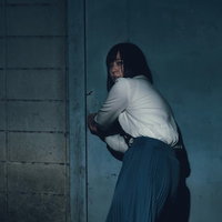 何かに追われて廃屋に逃げ込もうとする女性の写真