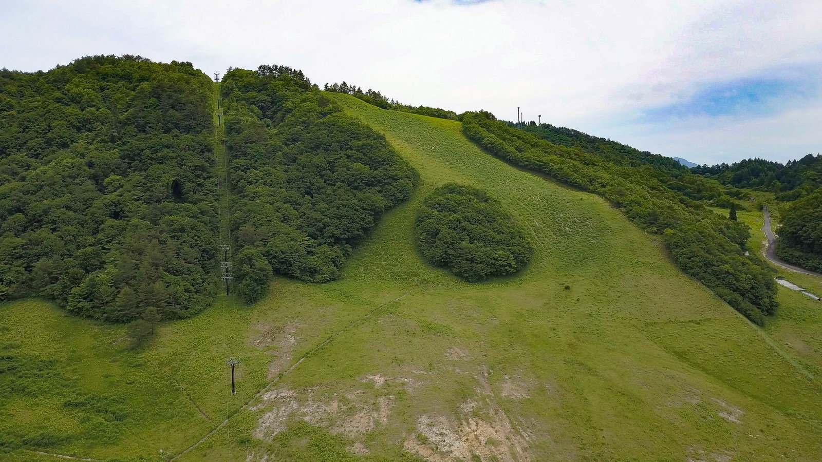 Lush green meadows and surrounding mountains at the Onohara Highland Ski Resort in early summer