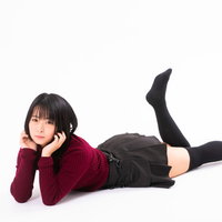 頬杖をついてうつ伏せで横たわる女性のポージングの写真