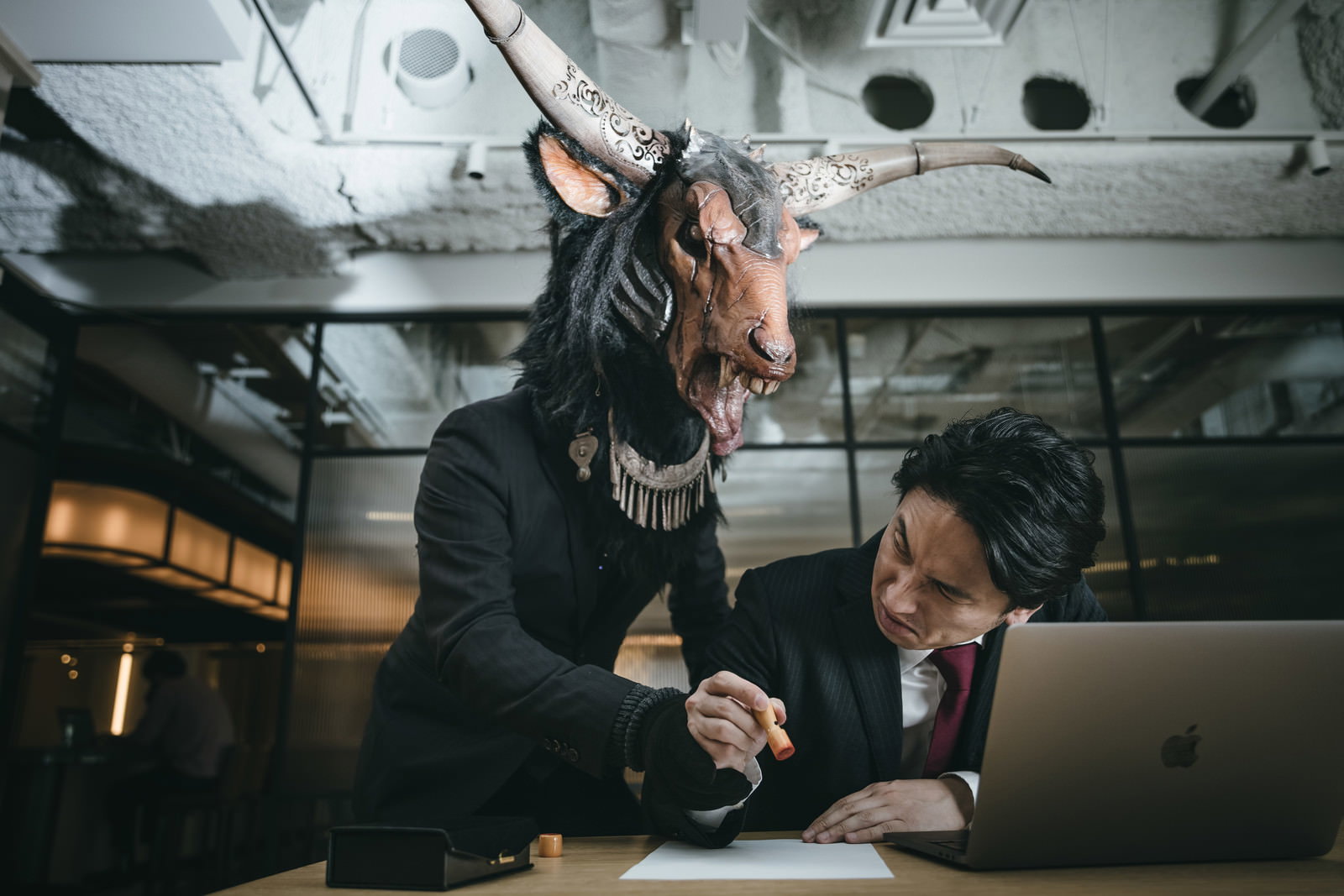 魔神サロンの加入を強要する信者。契約書を持つスーツの男性