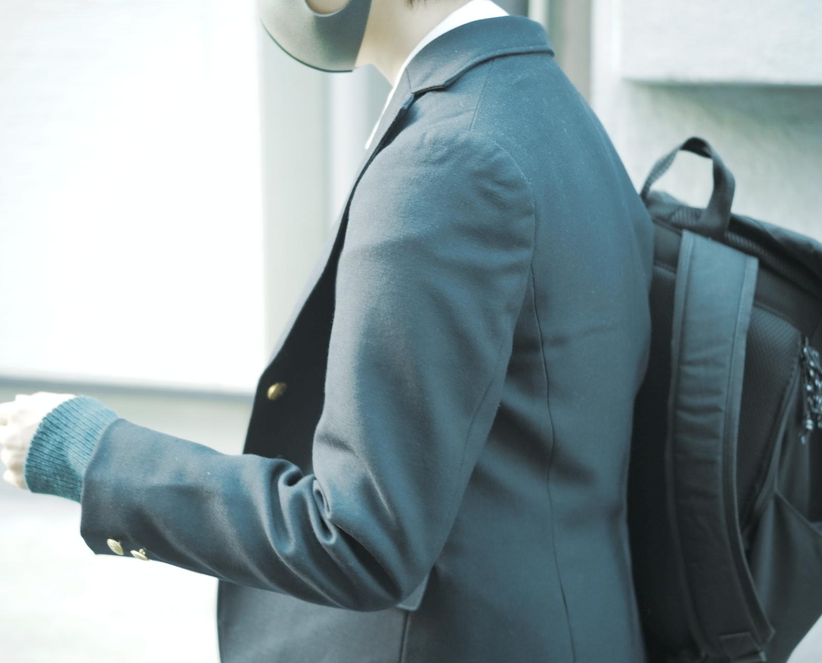 下校する青いブレザーの制服を着た高校生の後ろ姿