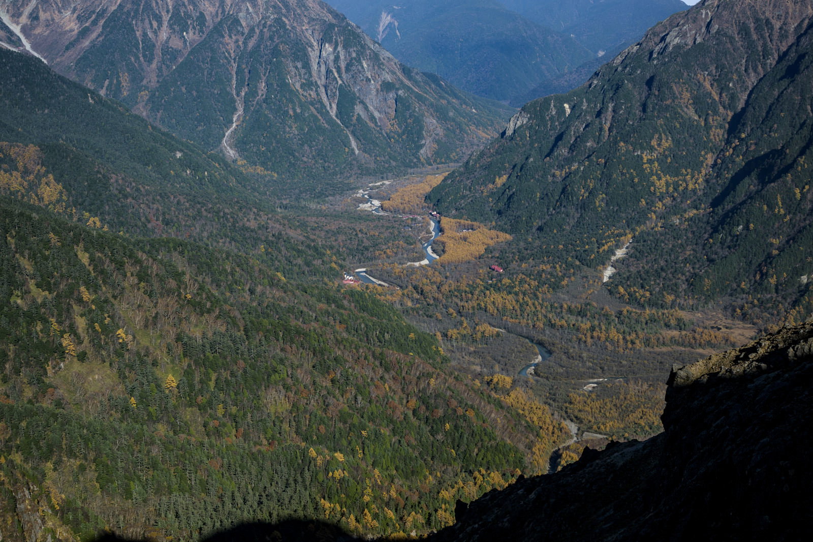 午後の光に照らされた上高地の渓谷と山々の風景