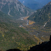 午後の光に包まれる上高地の山々と渓谷、焼岳の雄大な山岳風景の写真