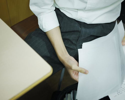 おもむろにプリントを整理しはめる居残り学生