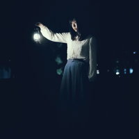 白いランタンを持ち歩く女性の不気味な夜間撮影の写真