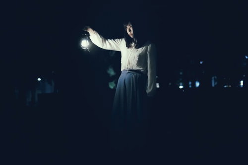 白いランタンを持ち歩く女性の不気味な夜間撮影