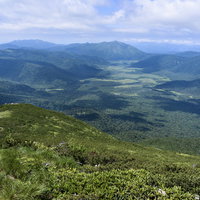 燧ヶ岳の山頂から見た尾瀬ヶ原の高原風景と遠くの山脈の写真