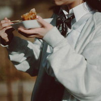 白い小皿で買い食いする制服姿の女子高生が下校中の写真