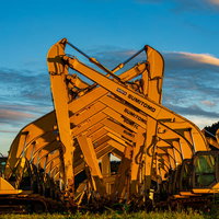 夕焼けの中でシンクロするショベルカーと建設機械の写真