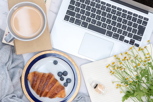 朝食をとりながらノートパソコンでリモートワークの風景
