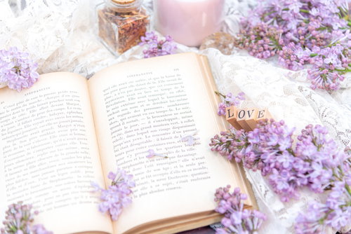 ライラックの花が添えられた開かれた洋書と生花