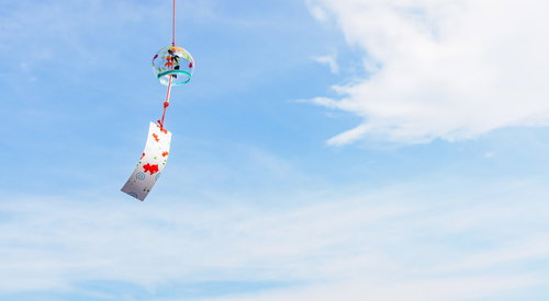 澄んだ青空に揺れる彩色風鈴、夏の涼を呼ぶ和風装飾