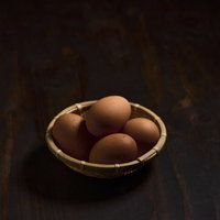 籠に置かれた茶色い卵の食材の写真