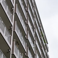 白いコンクリート造集合住宅の外観とベランダの連続の写真