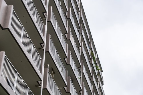 白いコンクリート造集合住宅の外観とベランダの連続