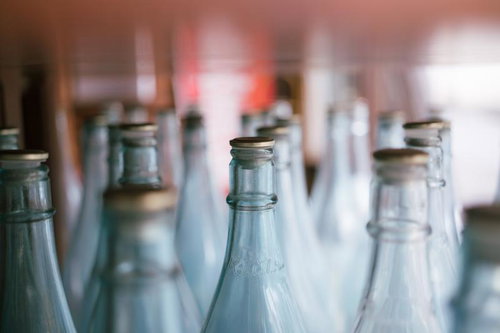 並んだ空き瓶と金属栓、リサイクル向けガラス瓶